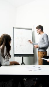 man and woman standing in front of whiteboard